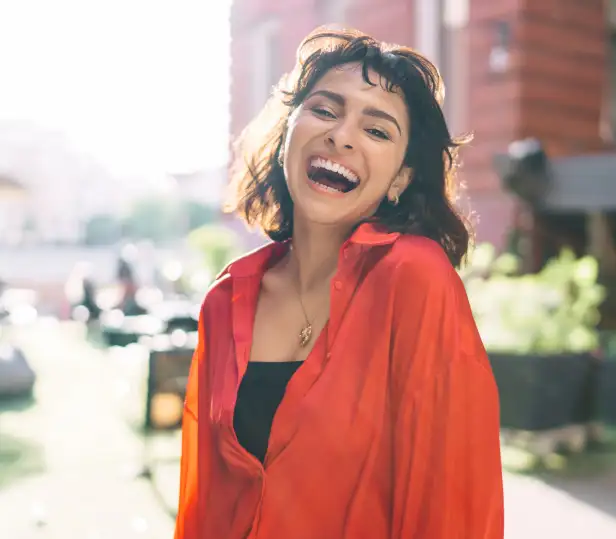 brunette in a red button up shirt laughing
