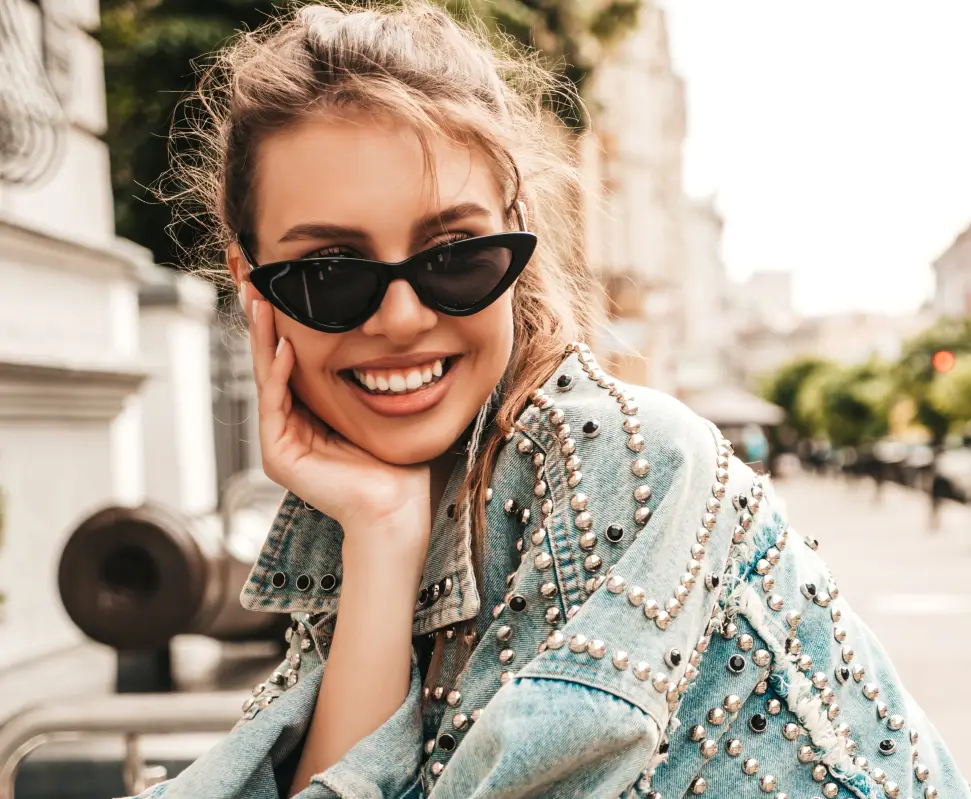 Raleigh woman smiling in black cat-eye sun glasses and a denim jacket